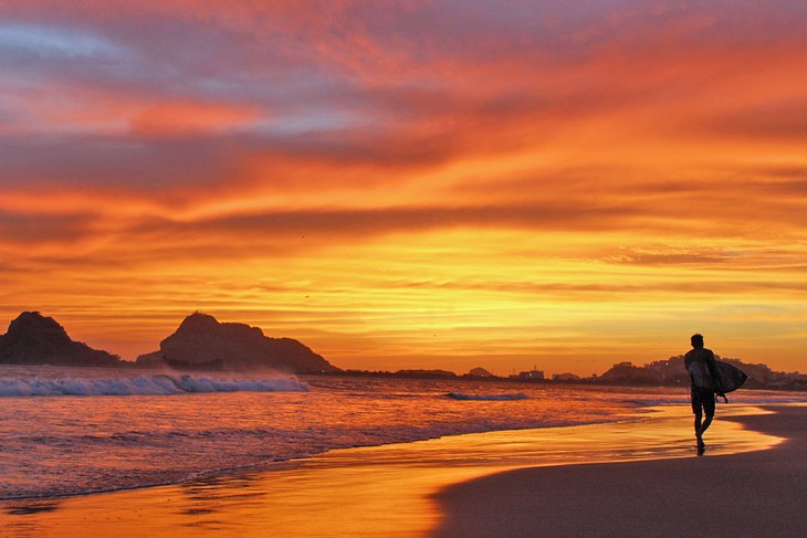 Surfer on the beach at sunset in Mazatlan