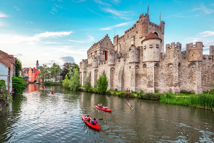 Kayaks cruising on a canal past the Gravensteen in Ghent