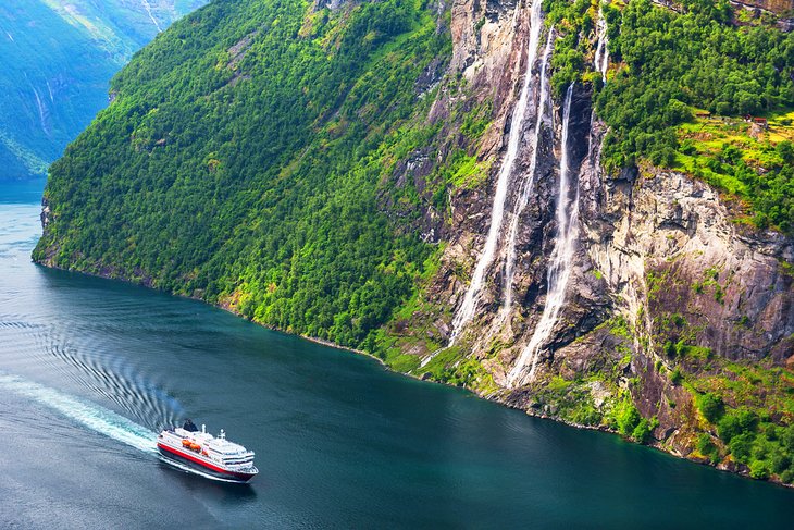 Cruise ship passing by Seven Sisters Waterfall in Sunnylvsfjorden fjord