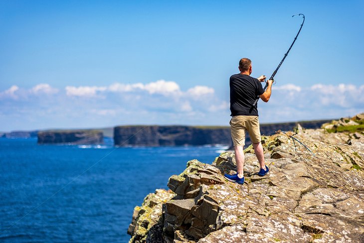 Fishing off the rocks at Loop Head Lighthouse, County Clare, Ireland