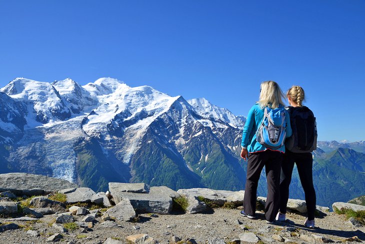 Hikers looking at Mont Blanc from the summit of Le Brevent