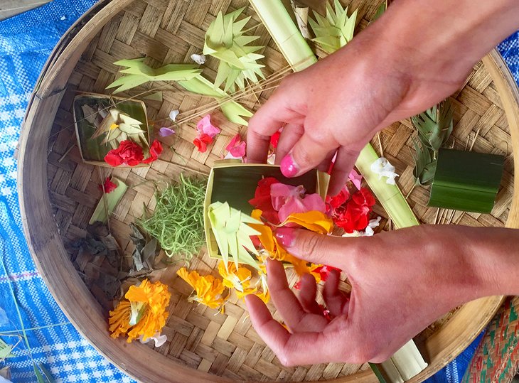 Making offerings in a local village on a bike tour in Bali