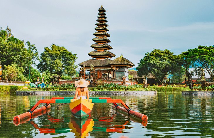 Woman in a outrigger in front of Pura Ulun Danu Bratan