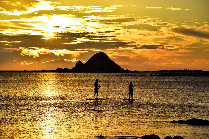 Stand up paddleboarders on Princess Bay at sunset