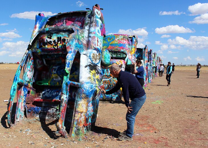 Author Michael Law painting on cars at Cadillac Ranch