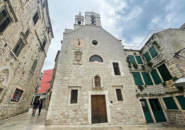 People walking by the Church of St. Barbara