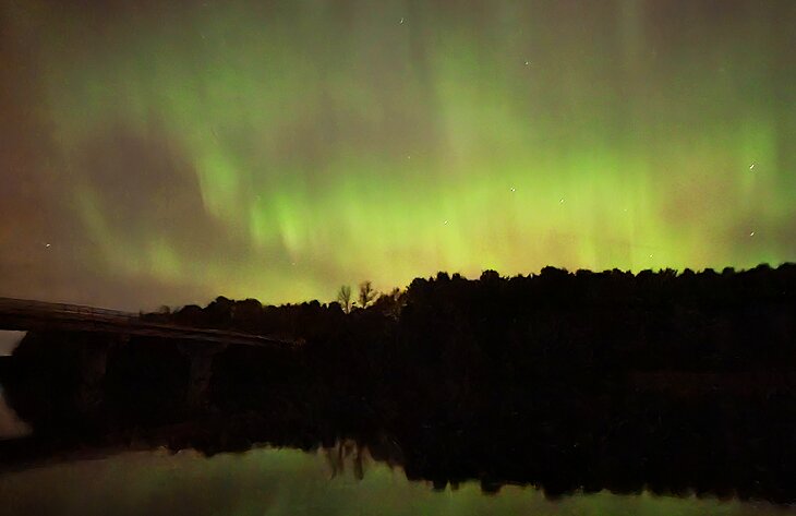 A bridge over a river in Southern Ontario with northern lights